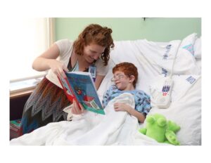 Trustee Sarah Nelson reading Hang On, Hester! to a child at Montefiore Medical Center.